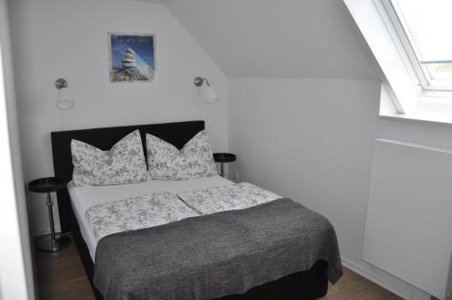 LütowFerienwohnung für vier Personen - b57337的一间卧室配有一张带灰色毯子和枕头的床