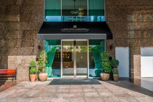 迪拜Ritz Carlton Residences DIFC Downtown Dubai的一间有黑色遮阳篷和盆栽植物的商店前