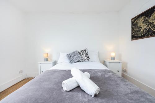 伦敦Stylish Apartment in Putney的一间卧室配有一张带白色毛巾的床