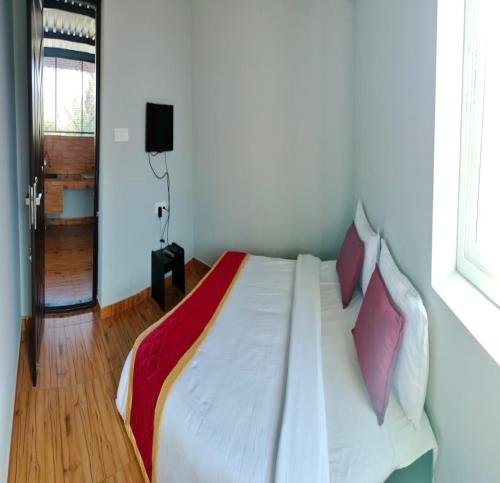 埃尔加德JK Resort的卧室配有白色床和紫色枕头