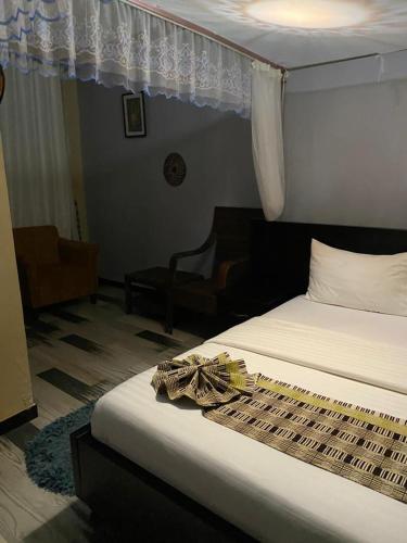 姆巴拉拉Life Lounge Guest house的一间卧室配有一张床、一把椅子和一张四柱床