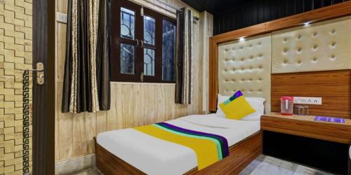 奈尼塔尔Hotel Flatties Mall Road Lake View Nainital的小卧室配有一张带黄色枕头的床