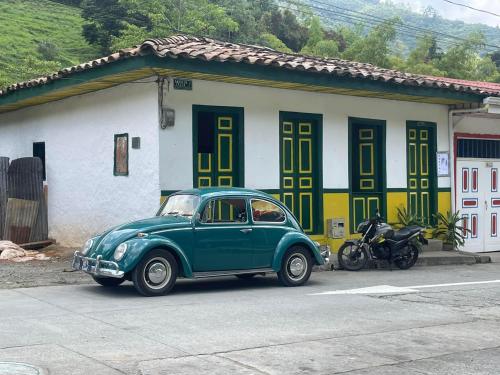 PijaoBOSQUE DE NIEBLA的停在房子前面的绿色汽车