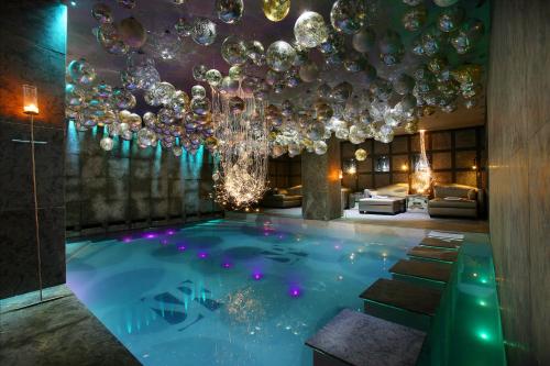 谷雪维尔Hotel Le Saint Roch的一间带吊灯的游泳池的客房