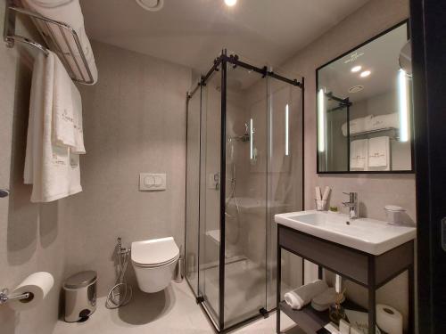地拉那Mulaj Hotel的带淋浴、卫生间和盥洗盆的浴室