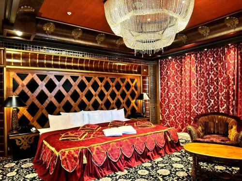 里加Royal SPA & Hotel Resort的一间卧室配有一张床、一把椅子和一个吊灯。