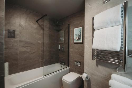科格索尔埃塞克斯高尔夫&乡村俱乐部酒店的带浴缸、卫生间和淋浴的浴室。