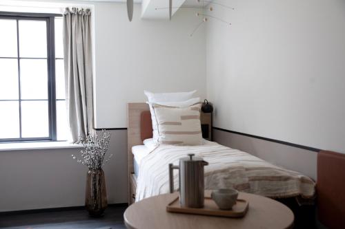 哥本哈根Bob W Østerbro Copenhagen的一间卧室配有一张带桌子和窗户的床