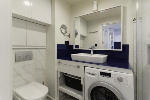 巴统Elite Class Sea View Aparthotel In Orbi City Batumi的一间带洗衣机和水槽的浴室
