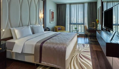 伊斯坦布尔Elite World Grand Istanbul Basın Ekspres的酒店客房设有一张大床和一台电视。