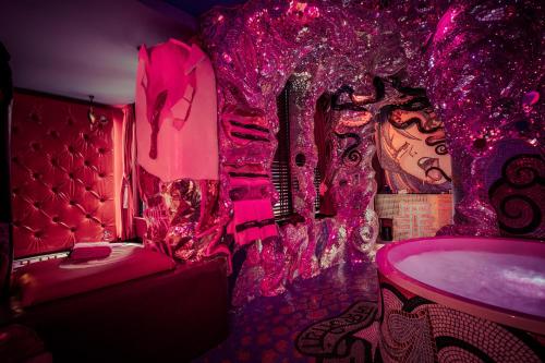 哈莱姆the Sin Suite的粉红色的客房设有一张床和一个浴缸。