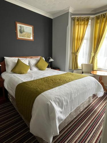 剑桥索伦托酒店&餐厅的一间卧室配有一张带黄色窗帘的大床