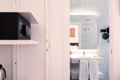 马德里Woohoo Rooms Boutique Luna的白色的浴室设有水槽和镜子