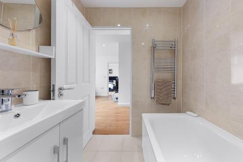赫默尔亨普斯特德Cozy Apartment in Hemel Hempstead的白色的浴室设有水槽和浴缸。