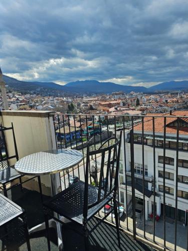 普里兹伦Skyland Apartment Prizren的阳台顶部的桌椅