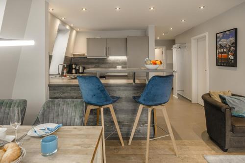蒂门多弗施特兰德Beach House Penthousewohnung Düne的一间带2把蓝色椅子的客厅和一间厨房