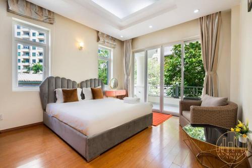 胡志明市KN3 Holiday Villa的一间卧室配有一张床、一把椅子和窗户。