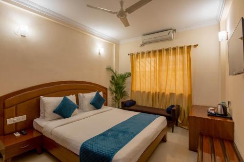 班加罗尔Blue Bliss Hotel By PPH Living的酒店客房设有床和窗户。