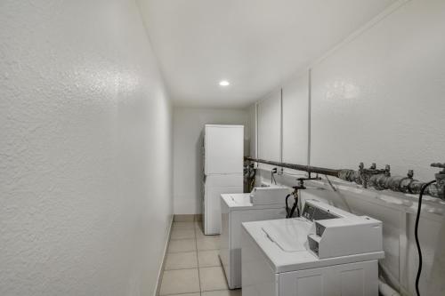 达拉斯达拉斯南部6号汽车旅馆的白色浴室设有3个水槽和1台冰箱。