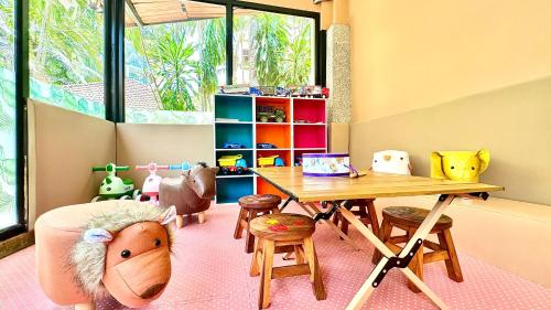 卡马拉海滩Princess Kamala Beachfront Hotel - SHA Extra Plus的儿童游戏室配有桌椅