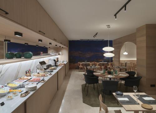 拉科鲁尼亚泽尼特拉科鲁尼亚酒店的餐厅设有长台面,配有桌椅