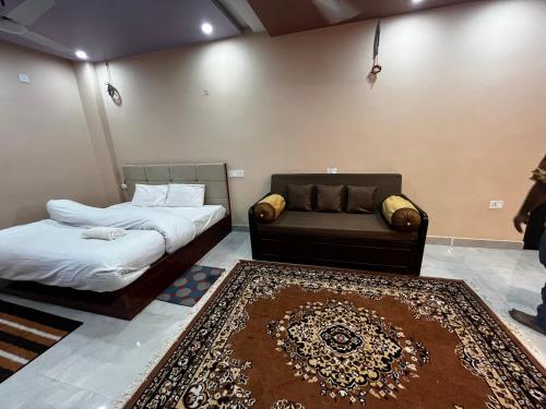 瓦拉纳西Preeti's Nest的一间客房配有两张床、一张沙发和地毯。