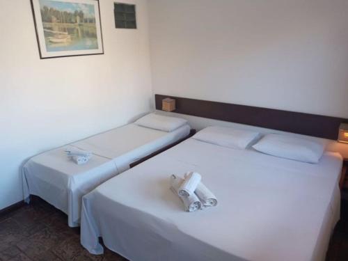 布希奥斯Calmaria Búzios的两张位于酒店客房的床,配有毛巾