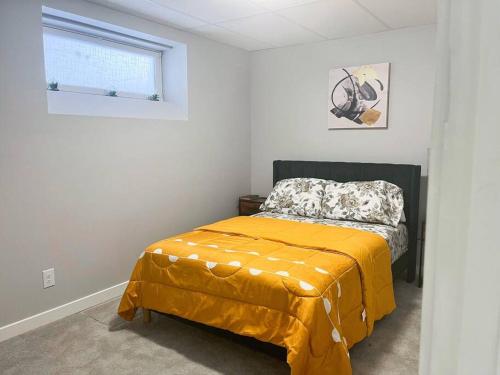 温尼伯Private Basement Suite with comfort的一间卧室配有一张黄色毯子床