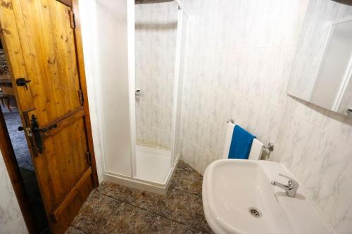 FolgosoA casa dos carros的浴室配有白色水槽和淋浴。
