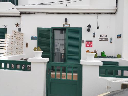 蓬塔穆赫雷斯Casa Leiva的绿色门,位于白色建筑中,设有绿色百叶窗