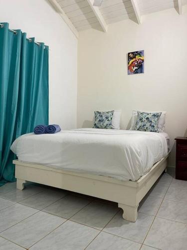 拉斯特拉纳斯Casita de 2 habitaciones的一间卧室配有白色的床和蓝色窗帘