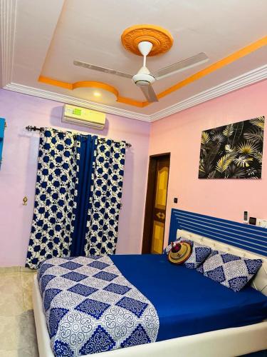 瓦加杜古Villa meublée climatisé en cours unique的一间卧室设有蓝色的床和天花板