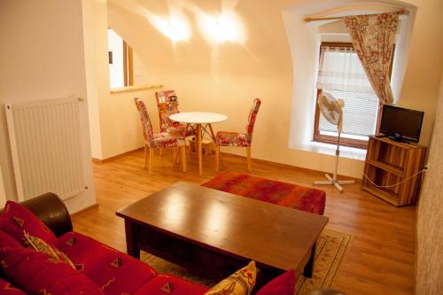 马里博尔Baščaršija Apartments & Rooms的客厅配有红色的沙发和桌子