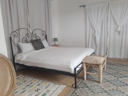 GhazouaDomaine de l'Arganeraie的一间卧室,卧室内配有一张床和一把椅子