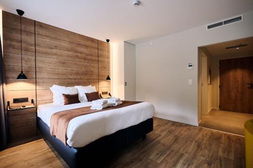 韦姆Le Mont Rigi的一间卧室配有一张大床和木制床头板