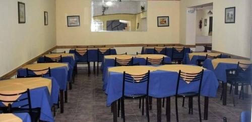 维拉卡洛斯帕兹Hotel Bellavista的一间摆放着桌椅和蓝色桌子的房间