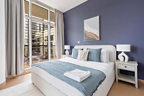 阿布扎比Silkhaus Luxurious 1 BDR Next to Golf Course的蓝色的卧室设有一张大床和一个窗户