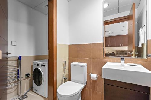 阿布扎比Silkhaus Luxurious 1 BDR Next to Golf Course的浴室配有卫生间、盥洗盆和洗衣机。