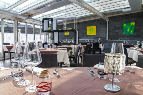 波朗特吕总站酒店的用餐室配有桌椅和酒杯