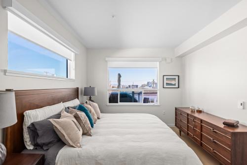 悉尼Modern 1000sqft+ Condo in Sidney, Ocean Views, Parking. Walk to Shops, Restaurants!的一间卧室设有一张大床和一个窗户。