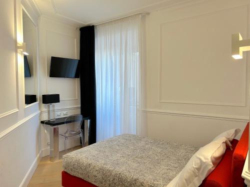 佛罗伦萨圭恰迪尼24号住宿加早餐旅馆的一间卧室配有一张床、一张书桌和一个窗户。