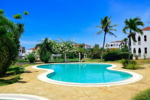 KikambalaChalbi residence-beach apartment at sultan palace的棕榈树庭院内的游泳池