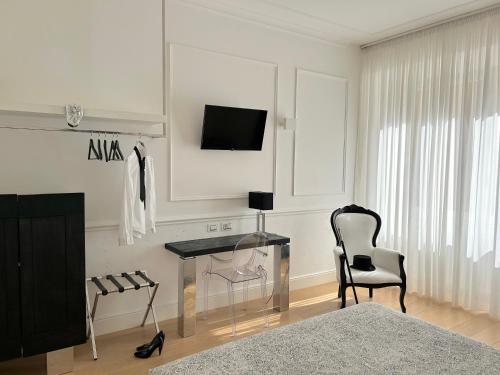 佛罗伦萨圭恰迪尼24号住宿加早餐旅馆的一间卧室配有书桌、椅子和电视。