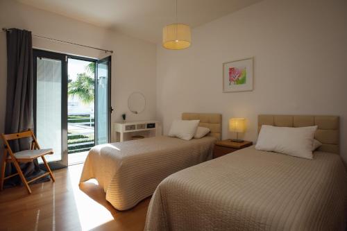 帕尔梅拉Villa Serena -your exclusive private swimming pool的一间卧室设有两张床和滑动玻璃门