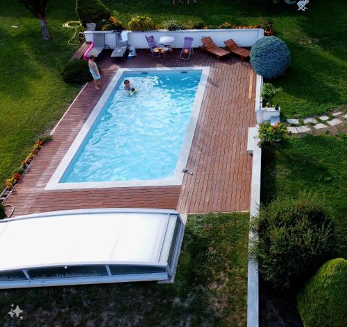 沙托鲁Chambres d'hôtes Les Peschiers的游泳池的顶部景色,游泳池里的人