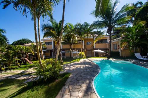 布希奥斯Hotel Latitud Buzios by Latitud Hoteles的享有带游泳池和棕榈树的度假村景色