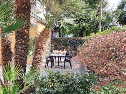 孔西里奥-迪鲁姆Apartment Elian by Interhome的棕榈树花园内的桌椅