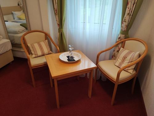 福尔巴赫Room in Guest room - Pension Forelle - Doppelzimmer的一间设有两把椅子、一张桌子和一张床的房间