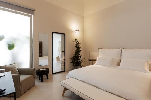 莱切Palazzo Console的卧室配有一张白色的大床和一张沙发。
