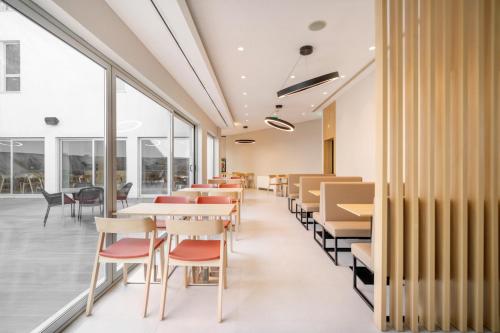 埃武拉埃武拉莫夫酒店的餐厅设有桌椅和大窗户。